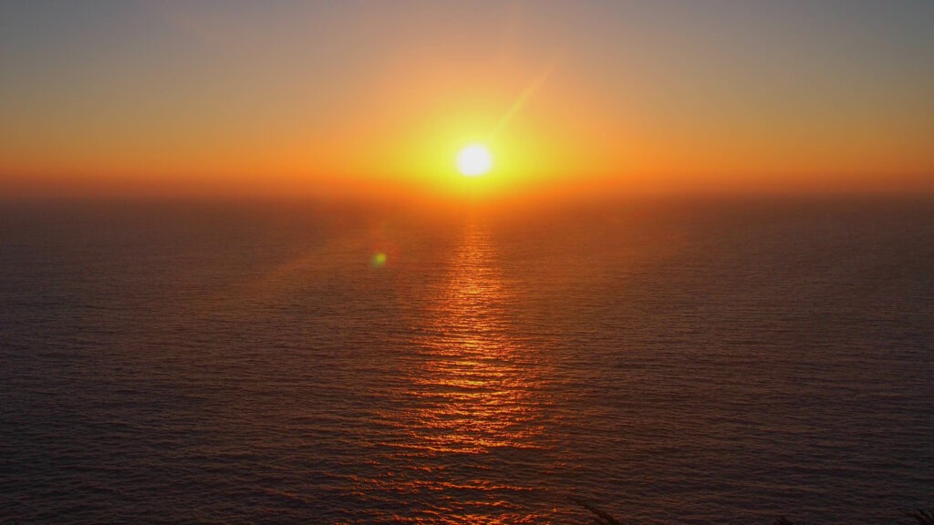 Coucher de soleil magique sur la Route 1 California, avec des baleines visibles au large.