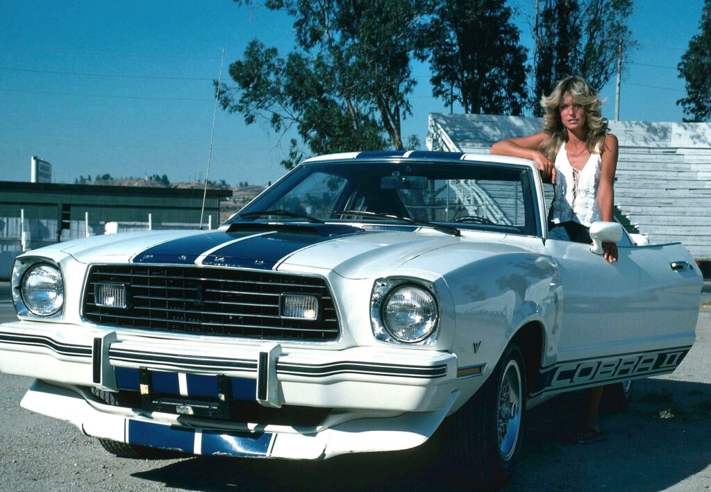 Dans la série Drôles de Dames de 1976, Farrah Fawcett conduit une Cobra II, tandis que Jaclyn Smith utilise une Mustang II coupé GHIA.