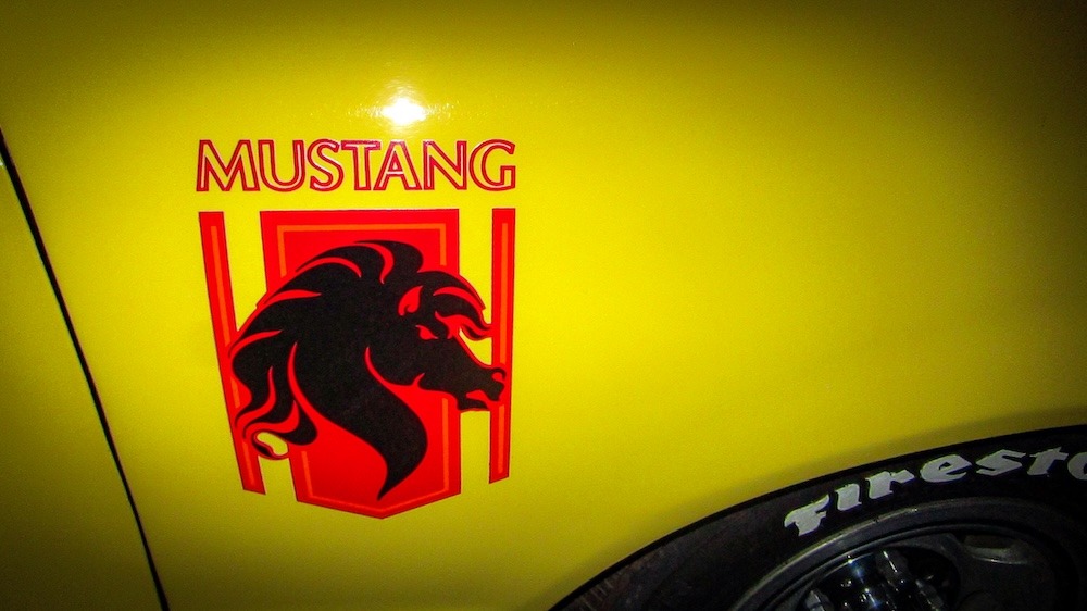 L'imposant logo de la Stallion est affiché sur les ailes avant grâce à des autocollants. Sur la Mustang de Robert, le fond rouge du logo contraste bien avec la peinture jaune de la carrosserie. Photo : Robert Aldrich