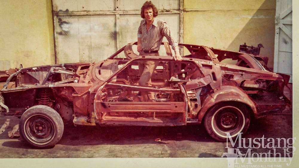 H.B. “Toby” Halicki pose au milieu de la coque dépouillée d’Eleanor pendant sa préparation. La voiture de cascade reçut notamment un arceau, des renforts et divers équipements spécifiques. Photo d’archive publiée dans Mustang Monthly / transmise pour recherche par Kurt Kaminer. Selon Donald Farr, Gone in 60 Seconds Inc. est propriétaire des droits.