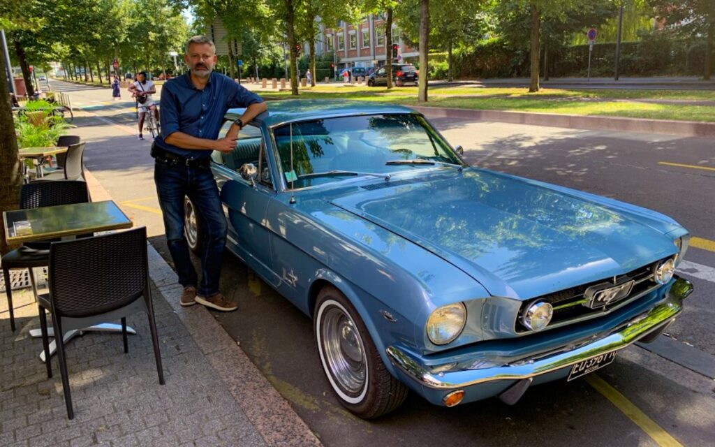 Stefan aux côtés de son coupé Mustang 1965 entièrement restauré, après un long voyage et de nombreuses heures de travail.
