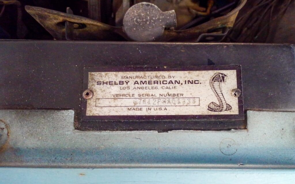 Riveté à l'aile avant, la plaque signalétique d'origine confirme en toute discrétion l'authenticité de cette Shelby GT500 de 1967.