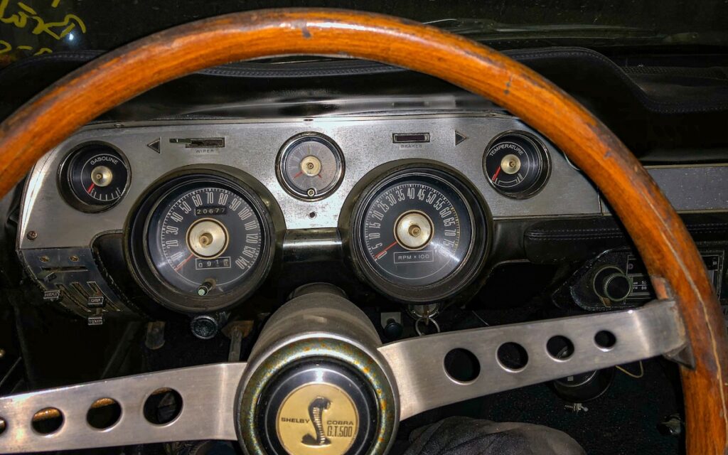 Le tableau de bord de 1967 et le volant Shelby replongent le conducteur à une époque où les « muscle cars » offraient des sensations brutes et mécaniques.