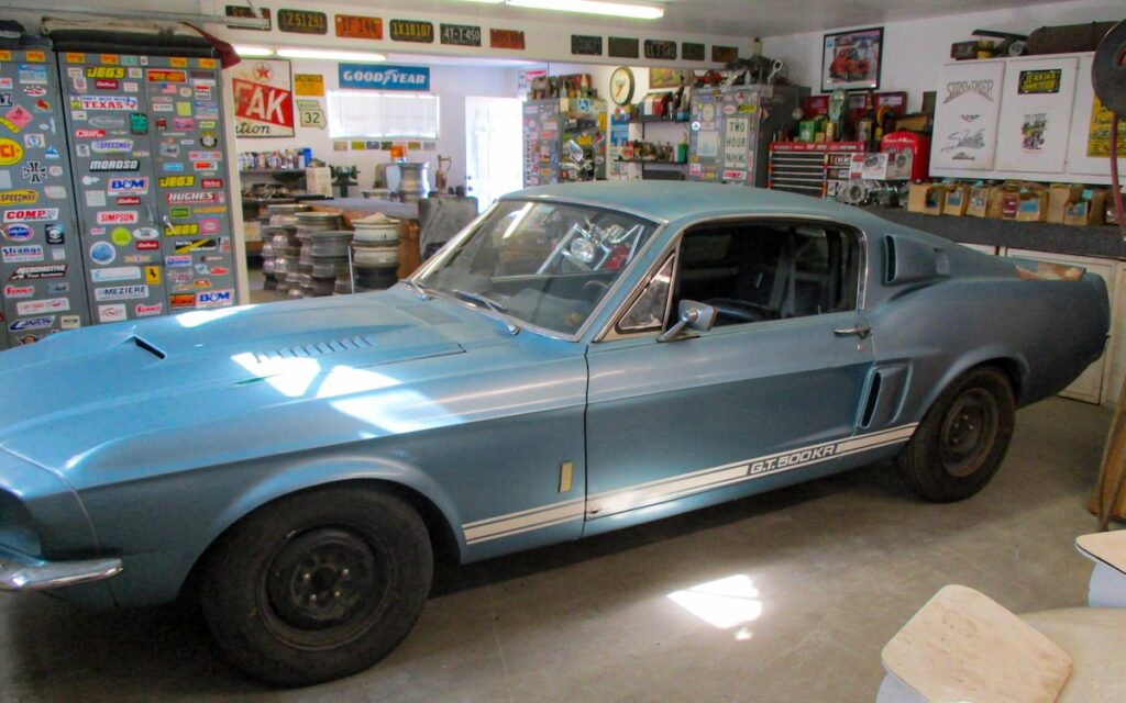 Stationné dans le garage, son long profil « fastback » laisse deviner la puissance et la prestance qui caractérisent la Shelby GT500 de 1967.