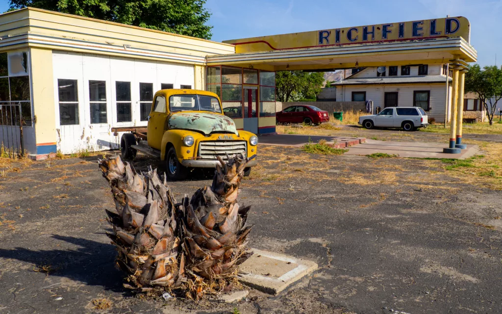 Un vieux pickup GMG dans une station-essence désaffectée.