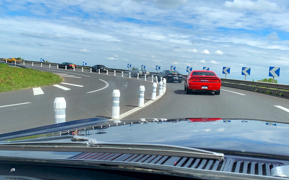 Le convoi de Mustang anciennes et récentes est accompagné par une Dodge Challenger.