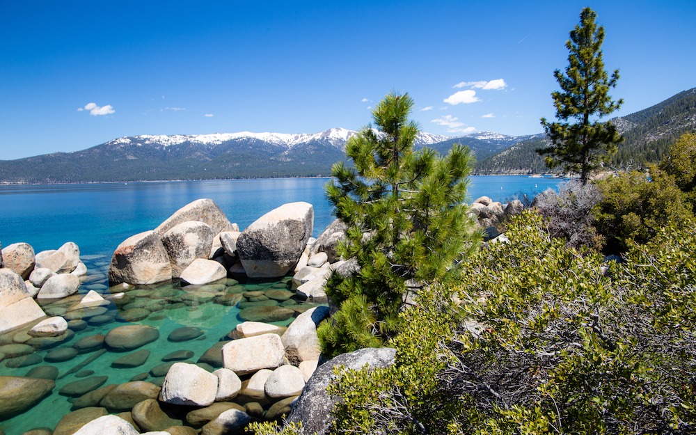 Vue panoramique de Sand Harbor au Lake Tahoe, avec sable doré et eaux turquoise cristallines.