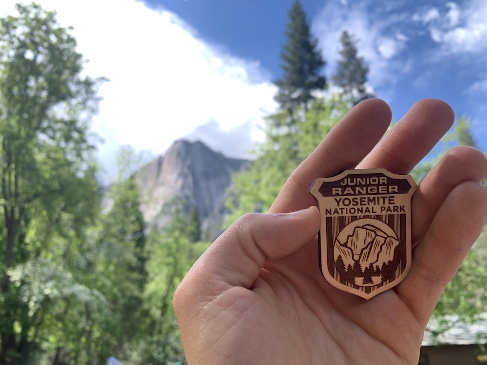Fierté et sourire au rendez-vous : Zoé brandit son badge Junior Ranger, symbole de sa promesse de protéger les parcs nationaux.
