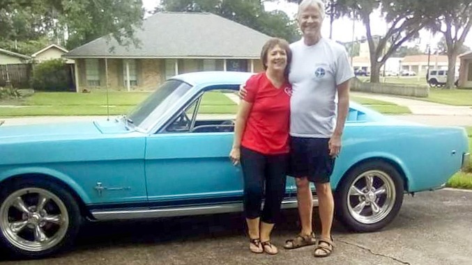 John et son épouse réunis devant la Mustang qui accompagne leur histoire depuis leur premier rendez-vous, en 1974.