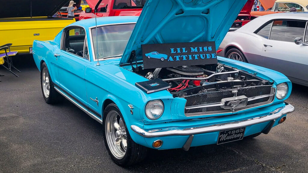Présentée capot ouvert lors d’un rassemblement, la Mustang arbore fièrement son surnom : « Lil Miss Attitude ».