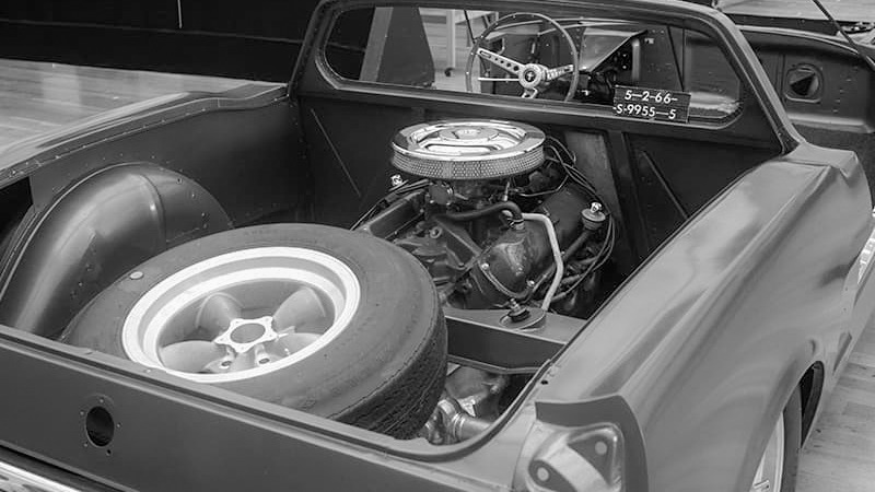 Vue arrière de la voiture expérimentale : le moteur est désormais installé derrière l'habitacle, tandis que le volant frappé du cheval Mustang rappelle les origines du prototype. Crédits : Ford Motor Company / Ford Archives