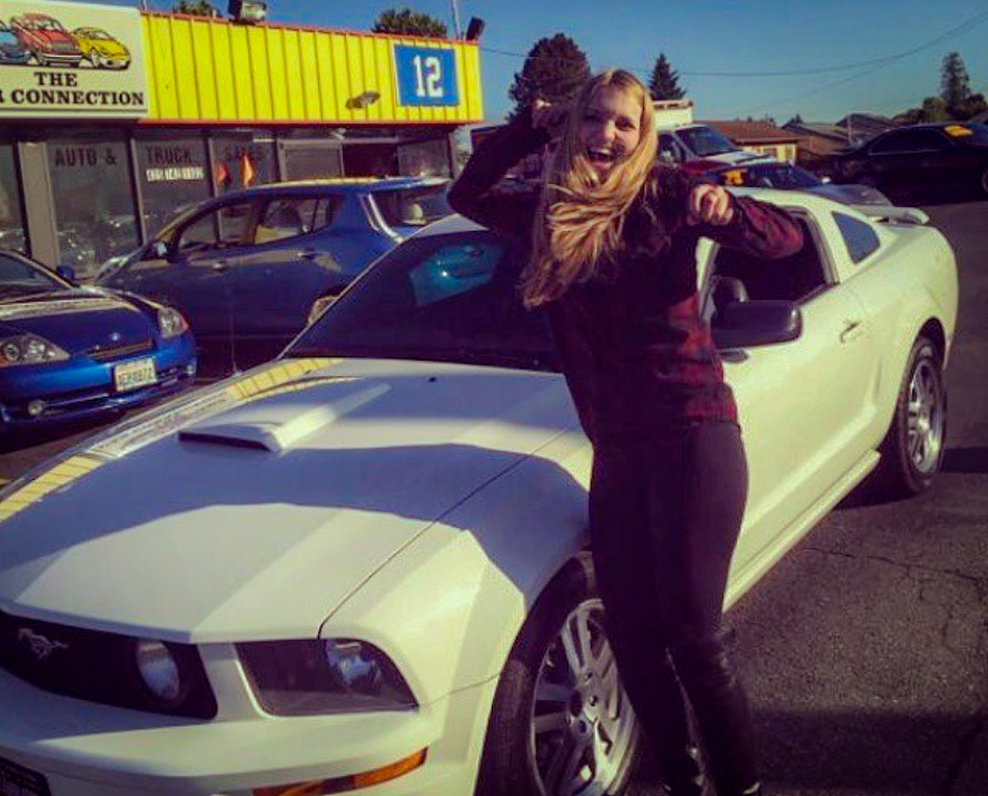 Brittley devant sa Mustang GT 2005 blanche lors de son achat