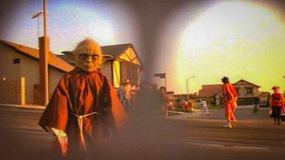 Parmi les enfants costumés, E.T. aperçoit Yoda et semble le reconnaître : un clin d’œil amusé à l’univers de George Lucas, déjà omniprésent dans la culture populaire américaine. © 1982 Universal City Studios, Inc.