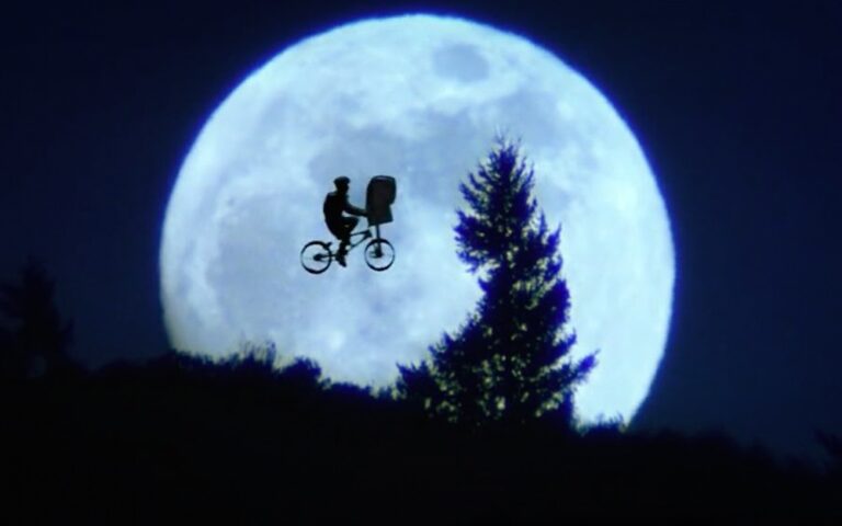Elliott et E.T. devant la lune : une image devenue l’un des symboles les plus reconnaissables du cinéma de Steven Spielberg. © 1982 Universal City Studios, Inc.