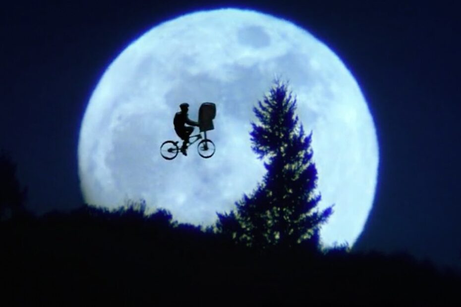 Elliott et E.T. devant la lune : une image devenue l’un des symboles les plus reconnaissables du cinéma de Steven Spielberg. © 1982 Universal City Studios, Inc.