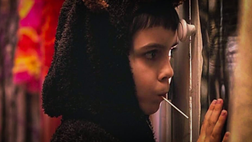 Malgré l’évolution spectaculaire des décorations, une tradition demeure : les enfants continuent de passer seuls de porte en porte pour réclamer leurs friandises. Crédits photo : capture de Trick ’r Treat © 2006 Warner Bros. Entertainment Inc.